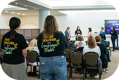 Two students standing in the back of a classroom